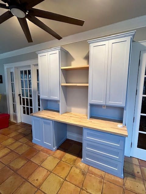 A room with a desk and a ceiling fan