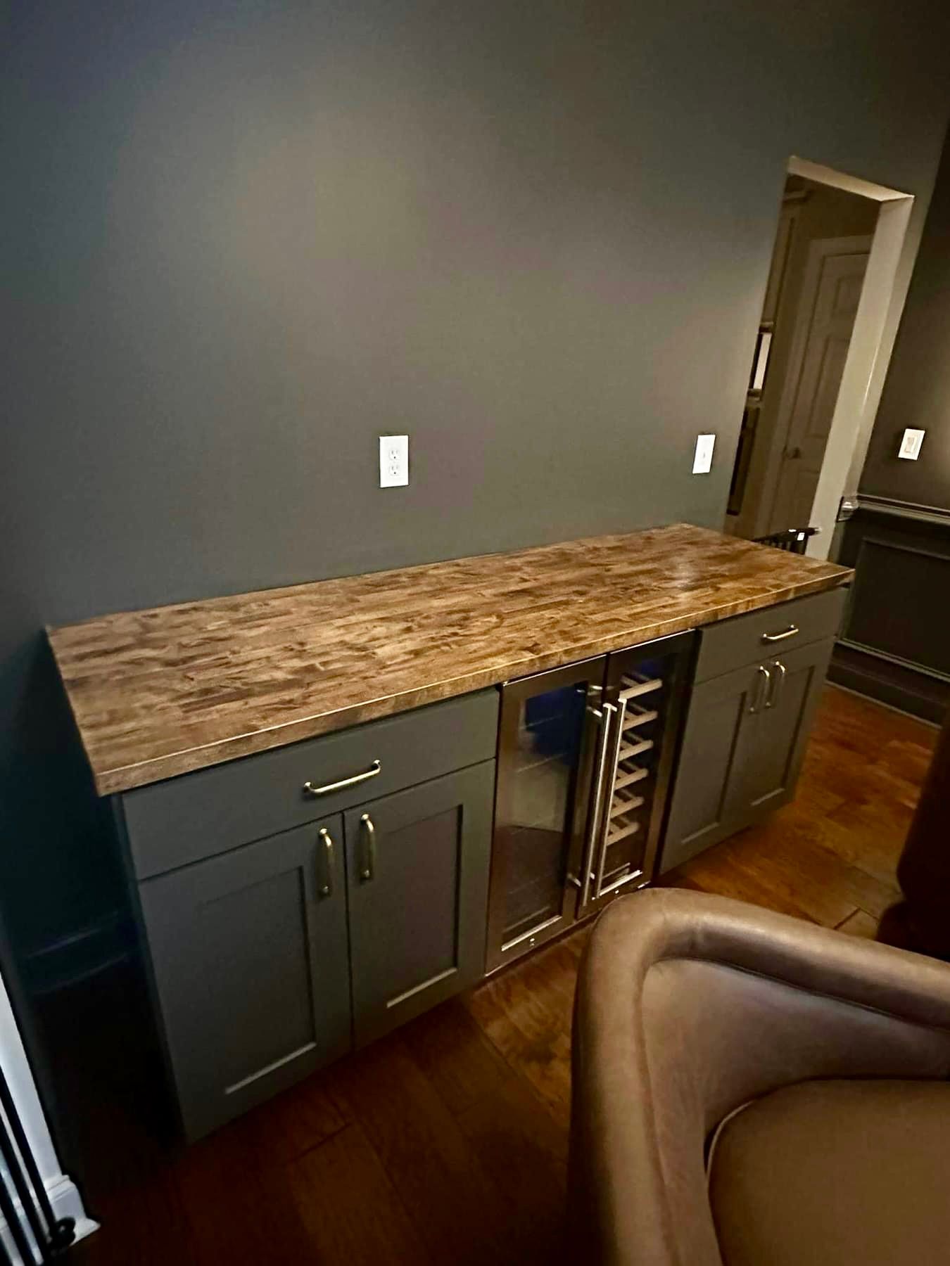 A kitchen with a marble counter top and a wine cooler.