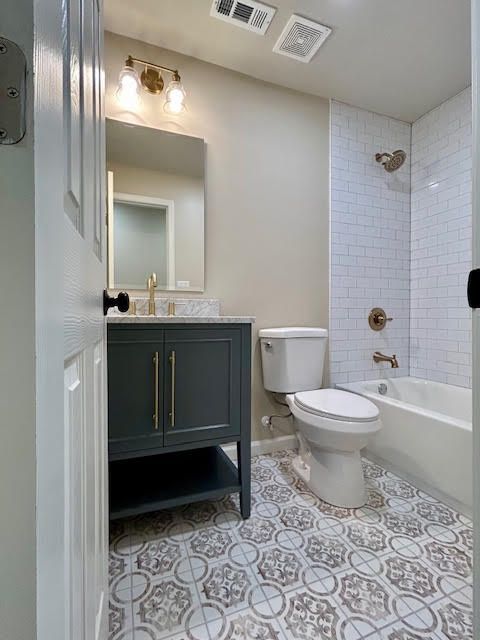 A bathroom with a toilet , sink , and bathtub.