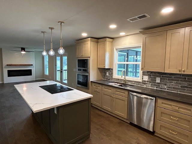 A kitchen with stainless steel appliances and a large island.