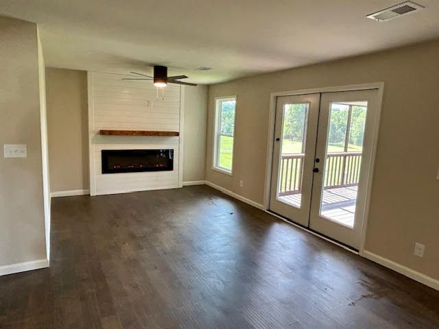 An empty living room with hardwood floors and a fireplace.