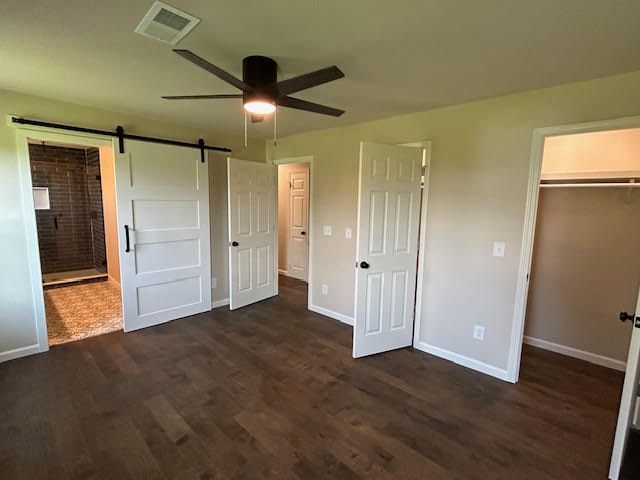 A bedroom with sliding barn doors and a ceiling fan.