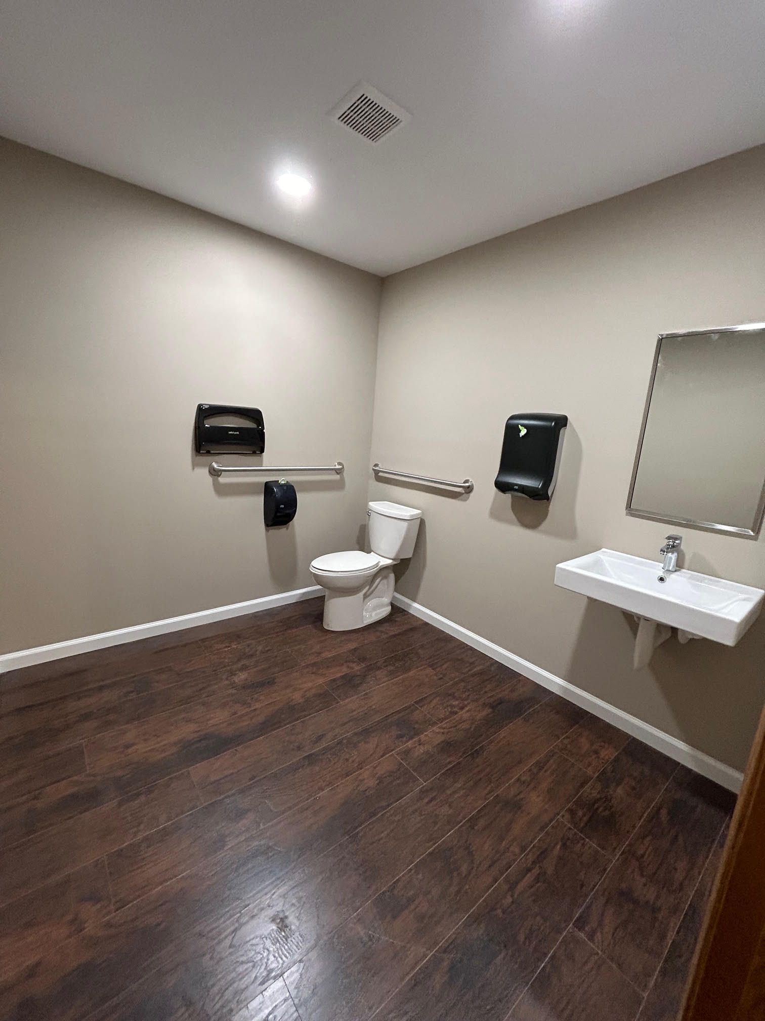 A bathroom with a toilet , sink and mirror.