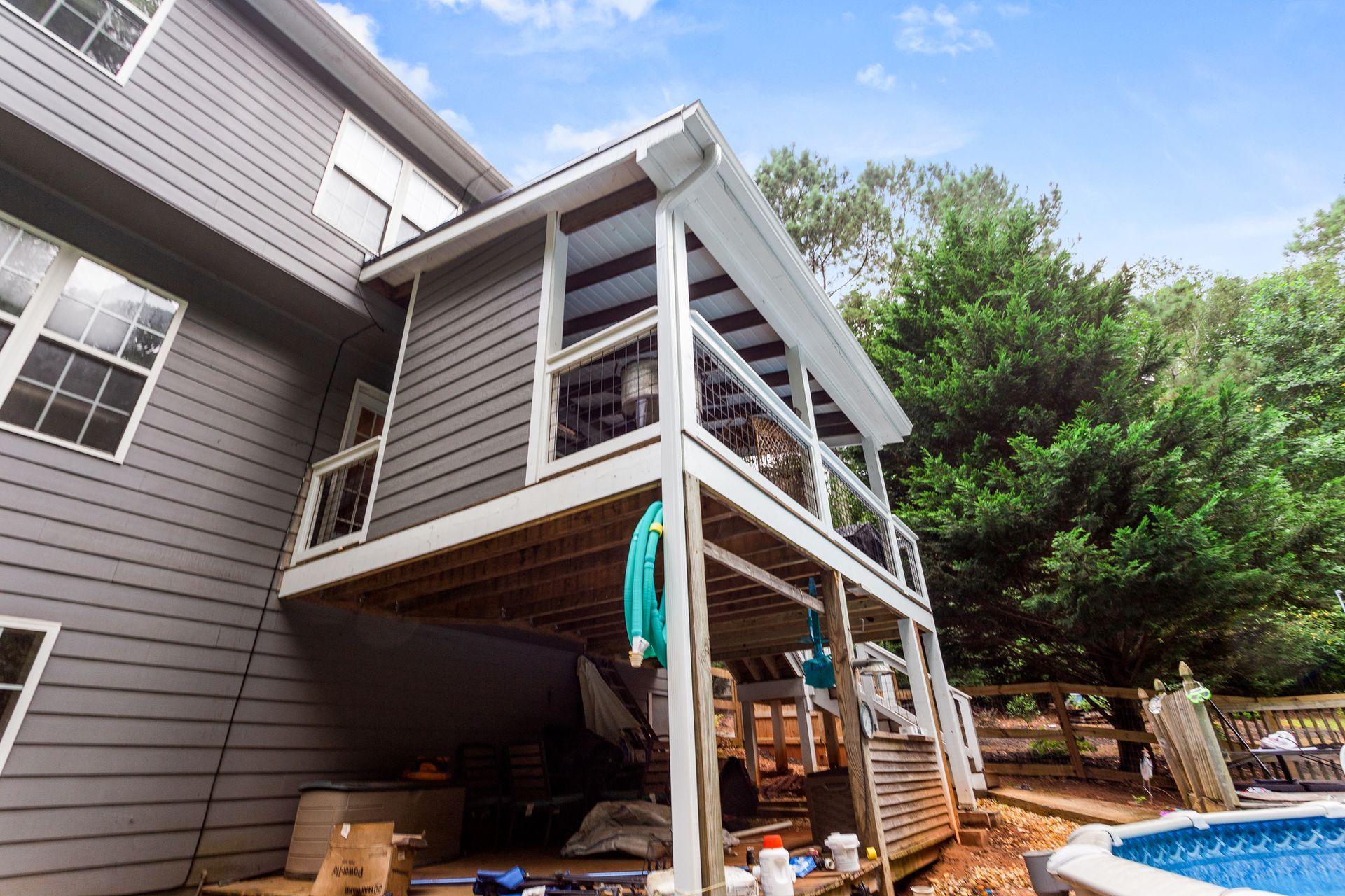 A house with a deck and a pool in the backyard.