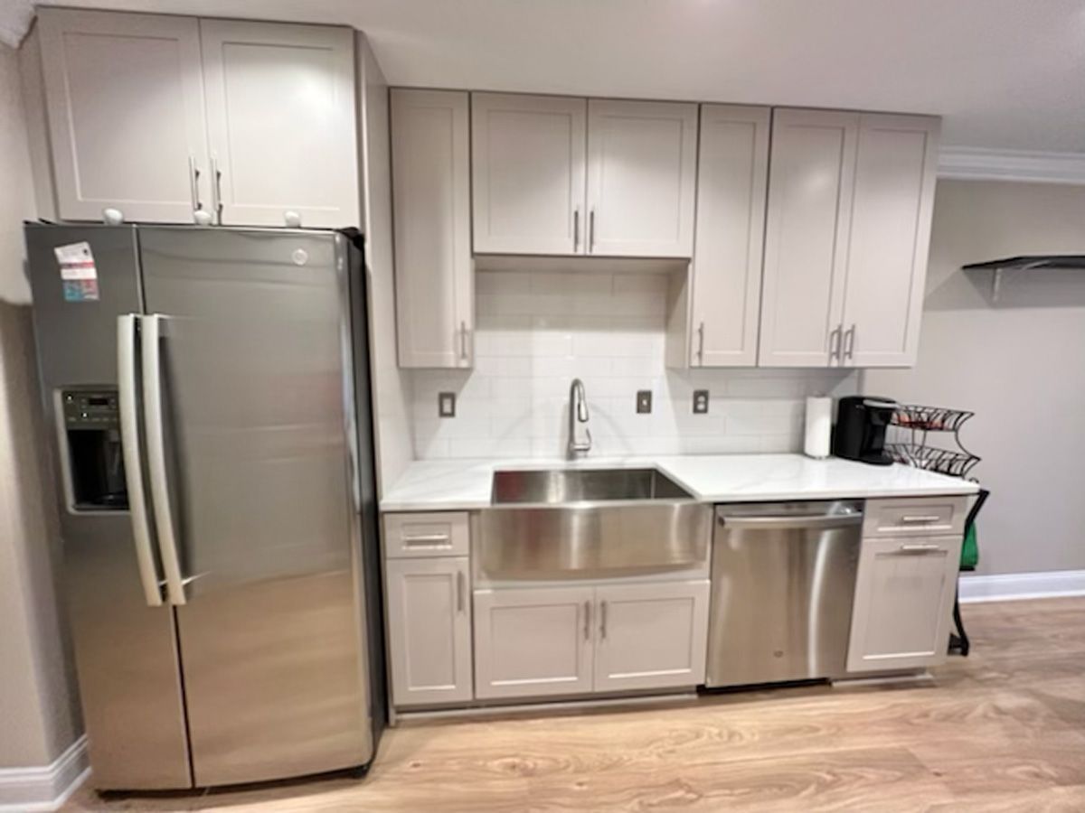 A kitchen with stainless steel appliances and white cabinets.
