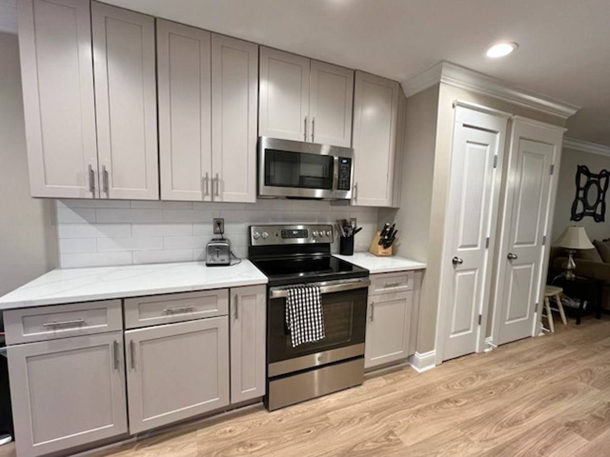 A kitchen with stainless steel appliances and white cabinets.