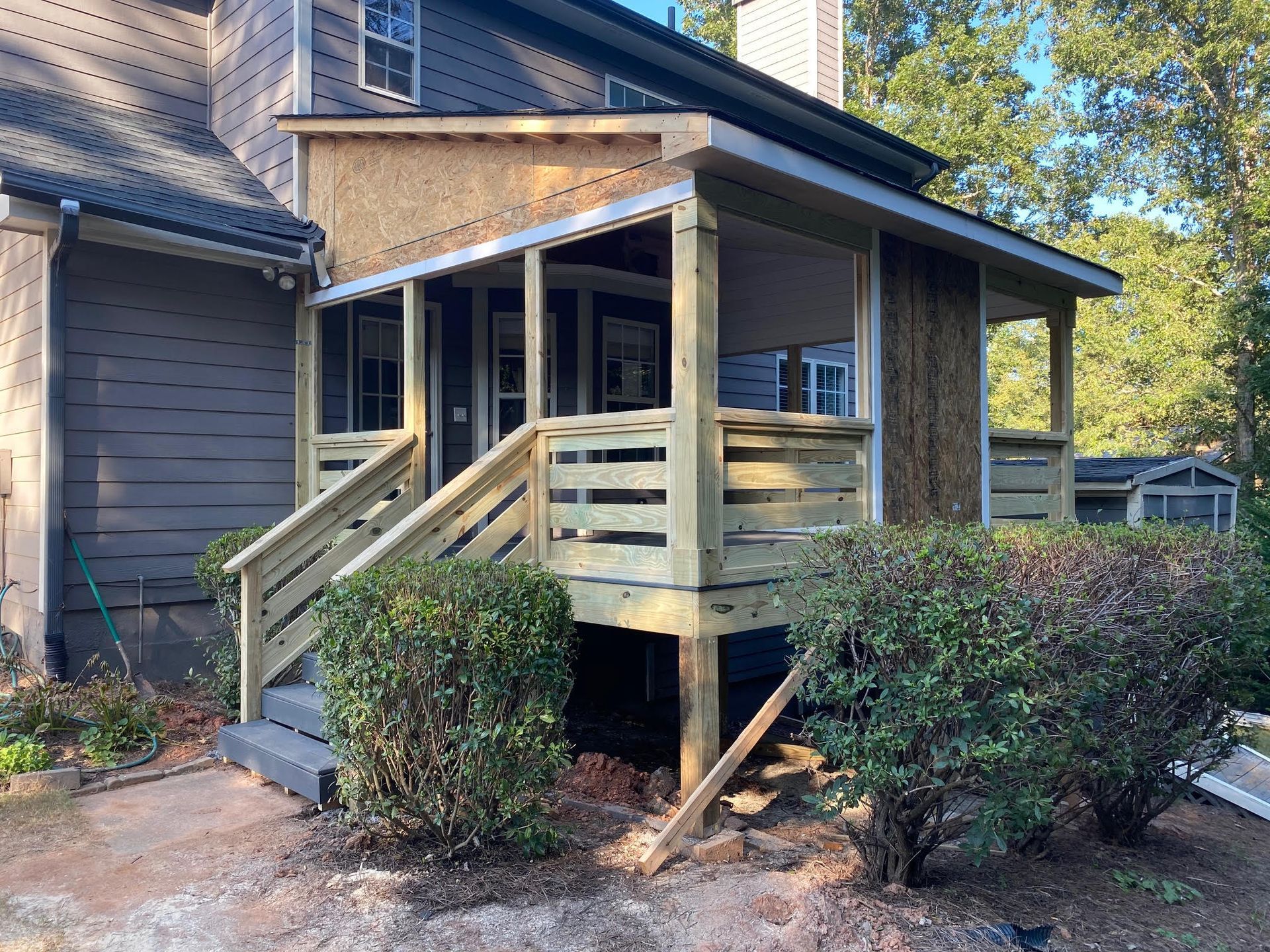 A wooden porch is being built on the side of a house.