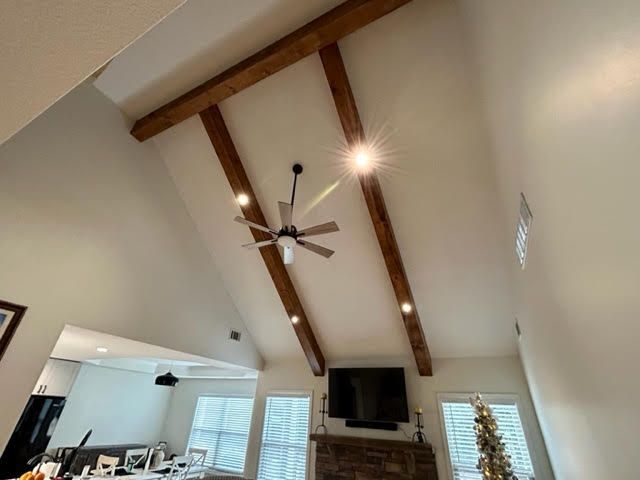A living room with a ceiling fan and a fireplace.