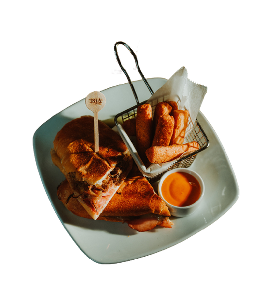 Plated assortment of fried appetizers with dipping sauce on a light green square plate with a basket of fries