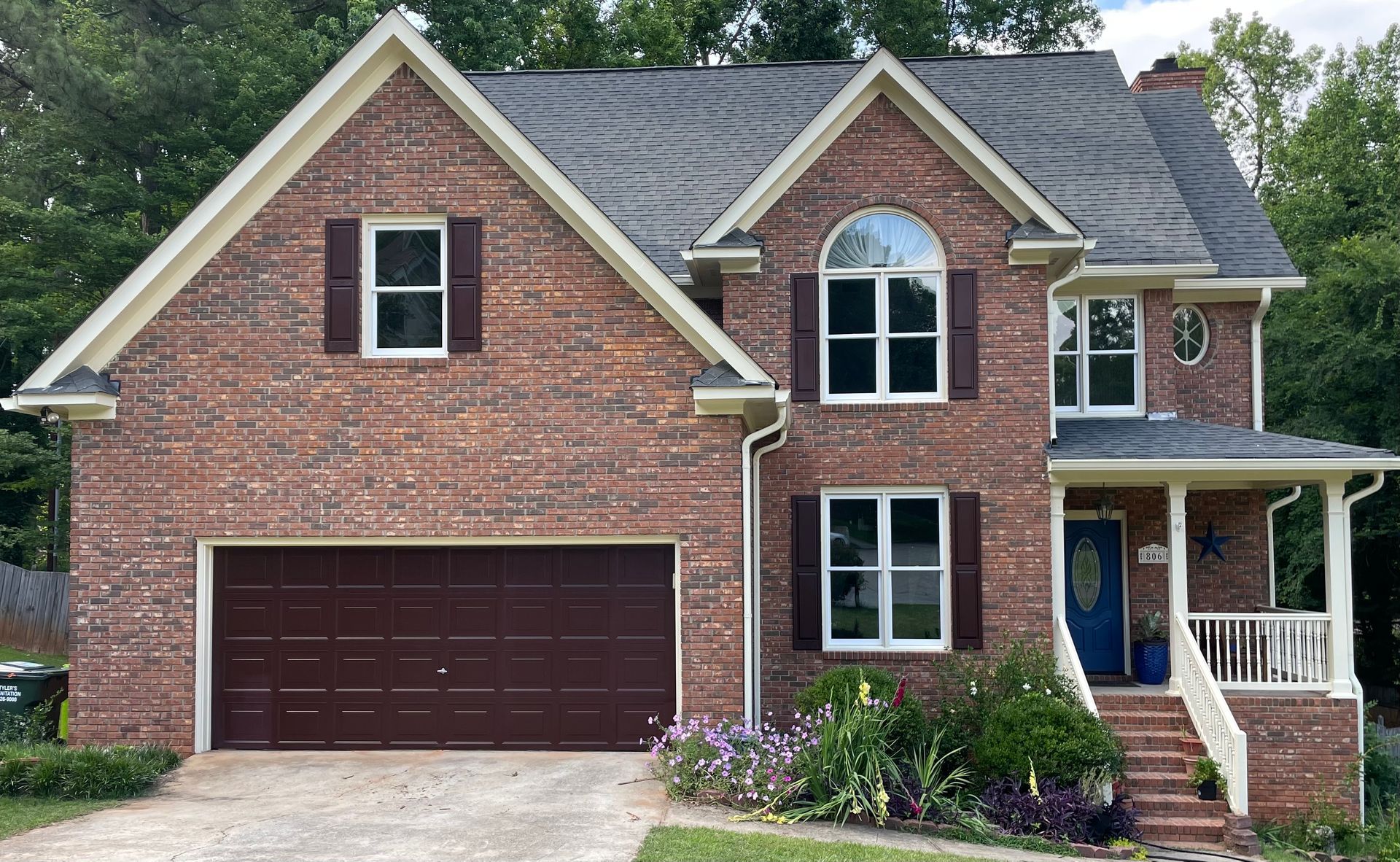 A large brick house with a brown garage door