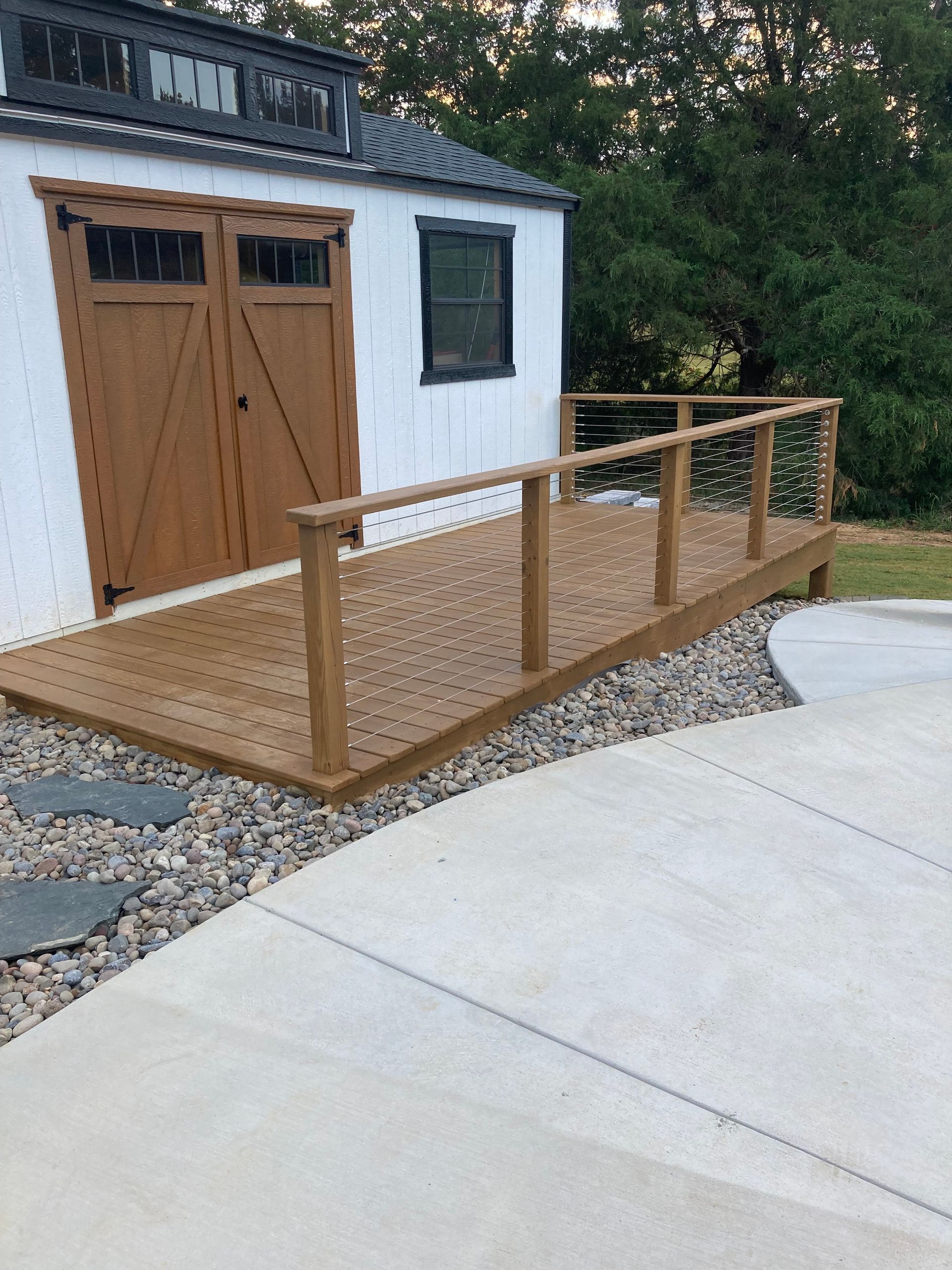 A wooden deck is sitting in front of a garage door.