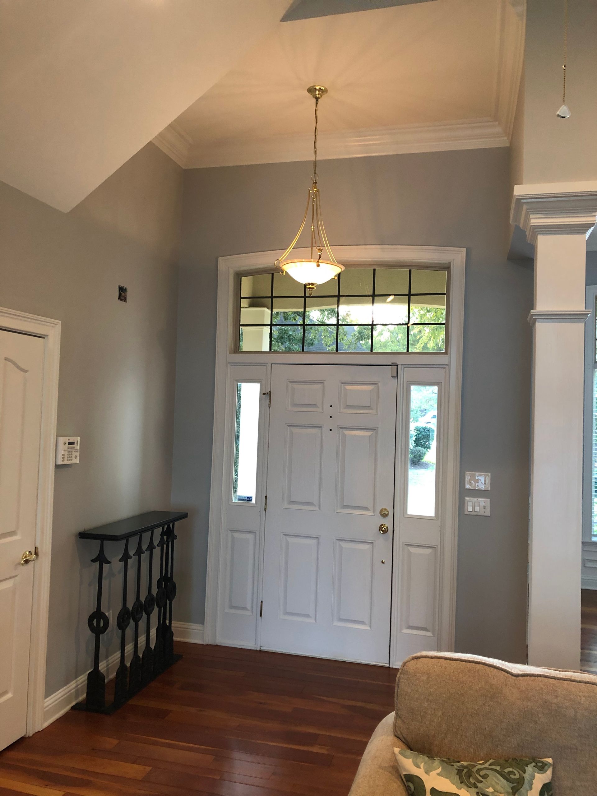 A living room with a couch and a chandelier hanging from the ceiling.