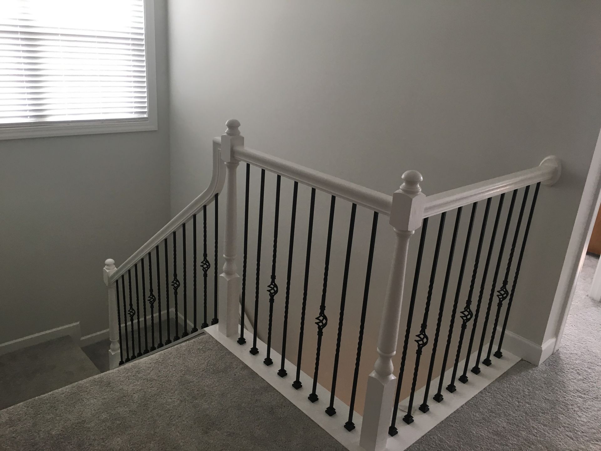 A staircase with a wrought iron railing in a house.