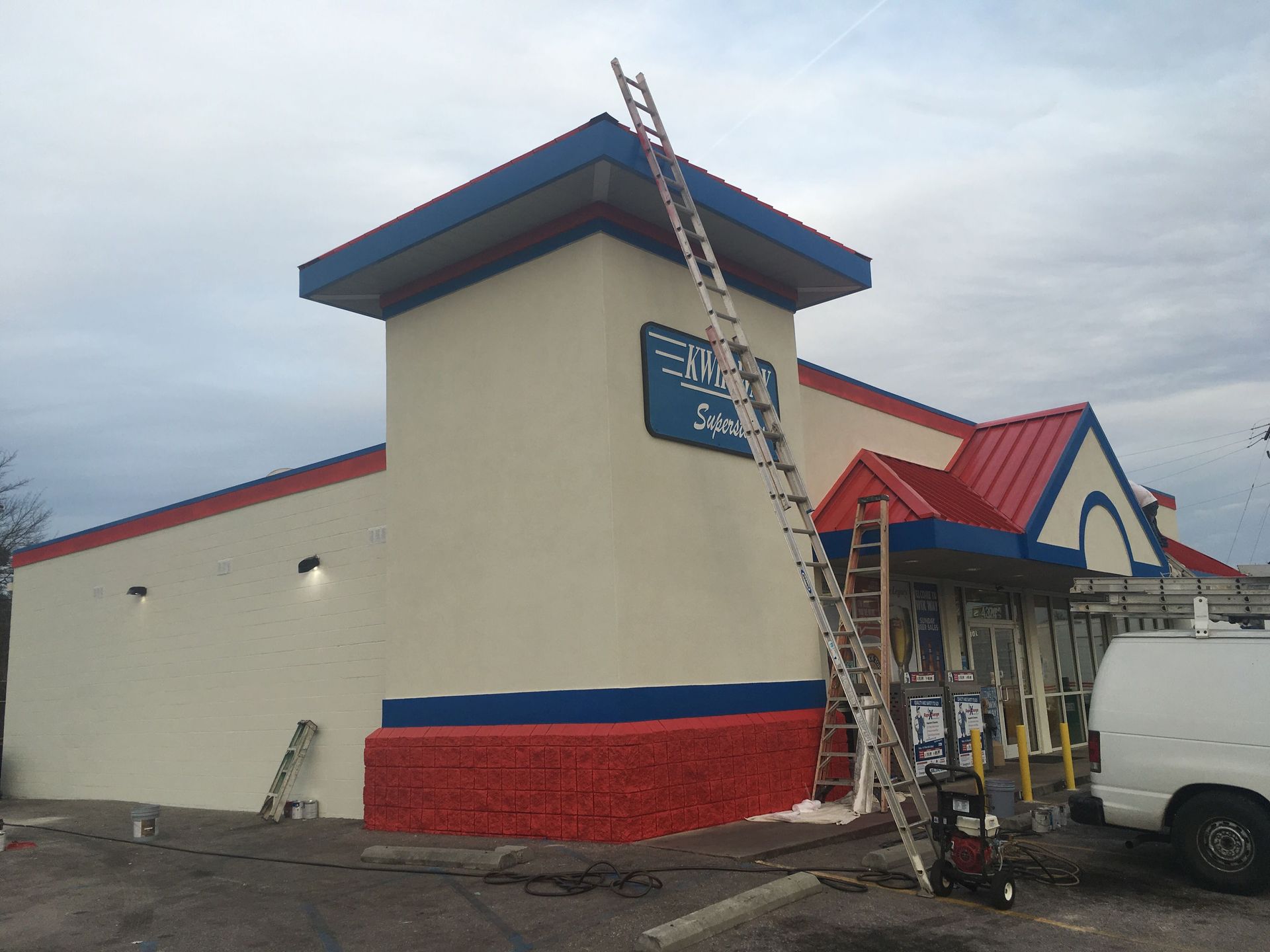 A red white and blue building with a ladder on the side