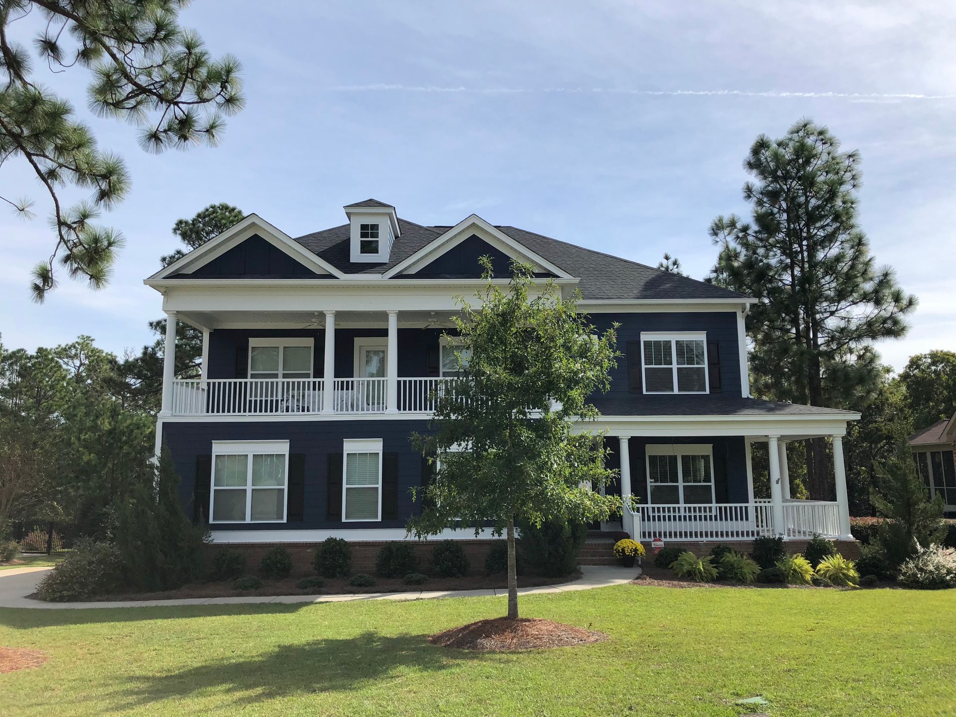 A large blue and white house with a large porch