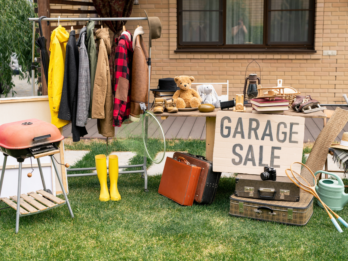 A garage sale is taking place in the backyard of a house.