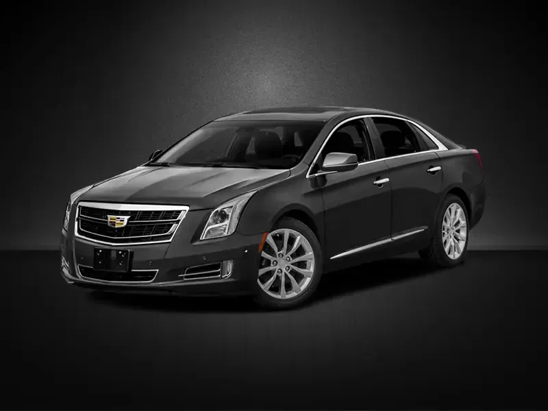 A black cadillac escalade is parked on a black background.