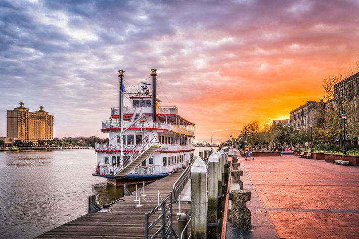 A boat is docked at a dock at sunset.