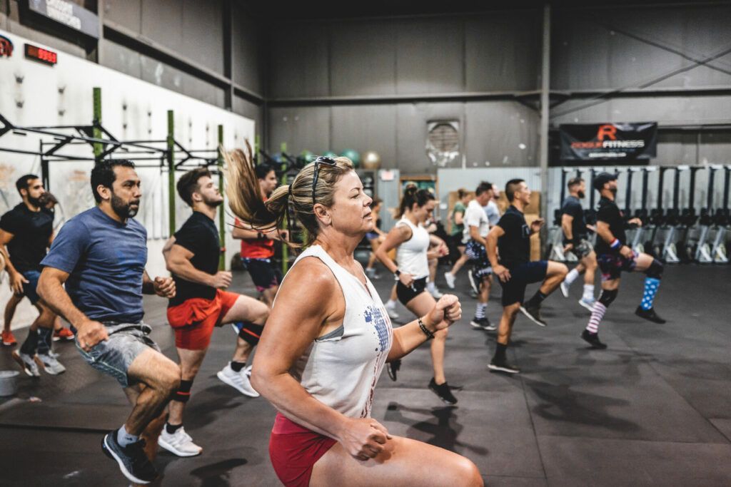 A group of people are running in a gym.