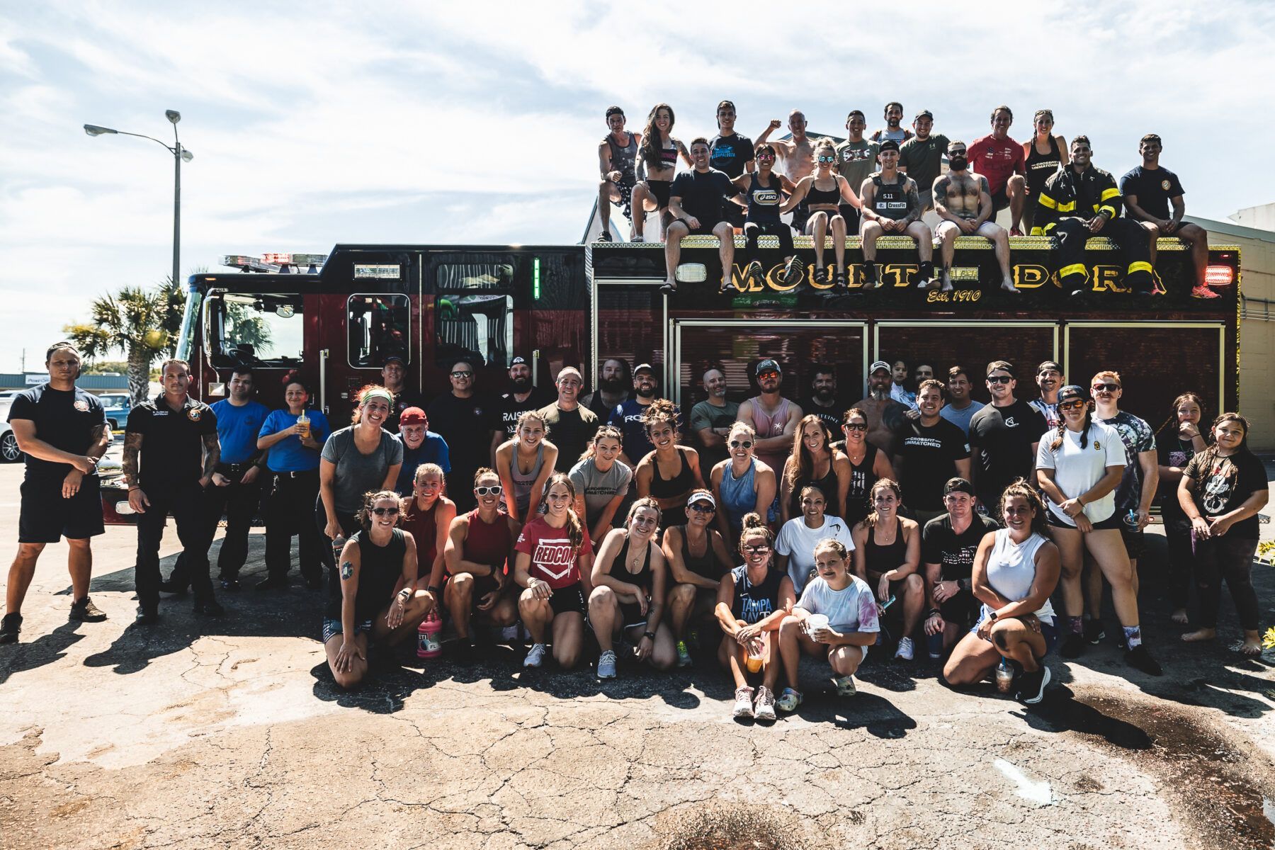 A large group of people are posing for a picture in front of a fire truck.