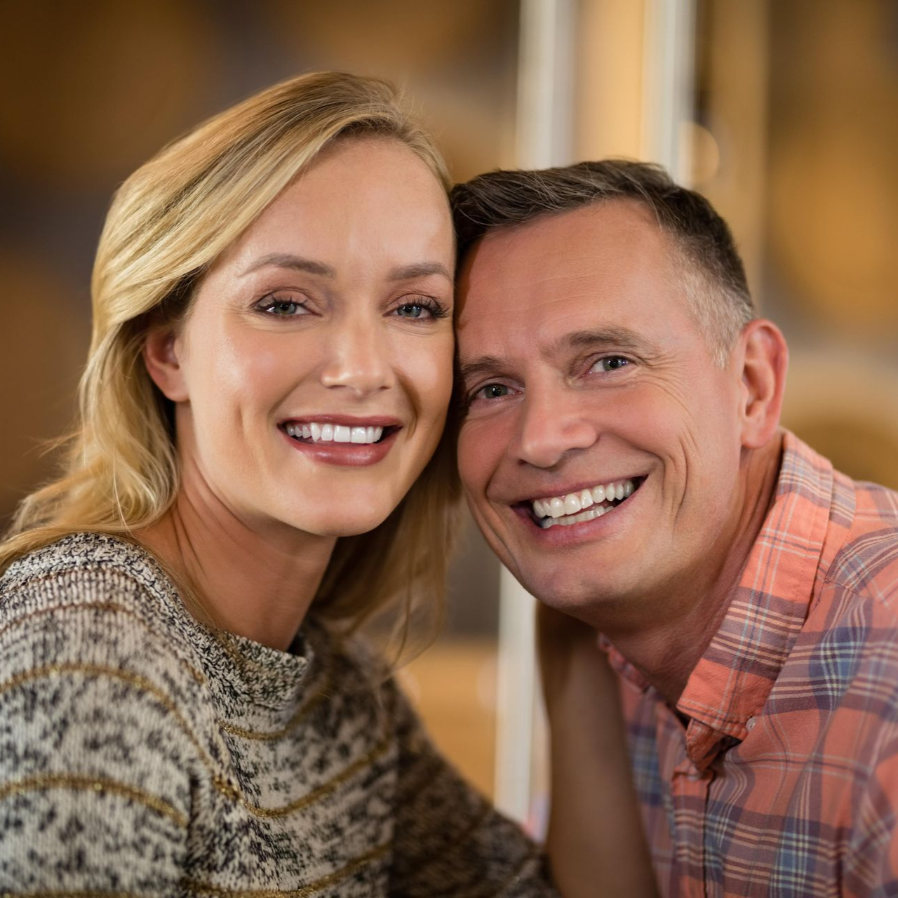 Smiling couple, woman with blonde hair, man in a pink plaid shirt, close-up.