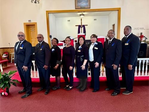 Group of people in formal attire standing in a church.