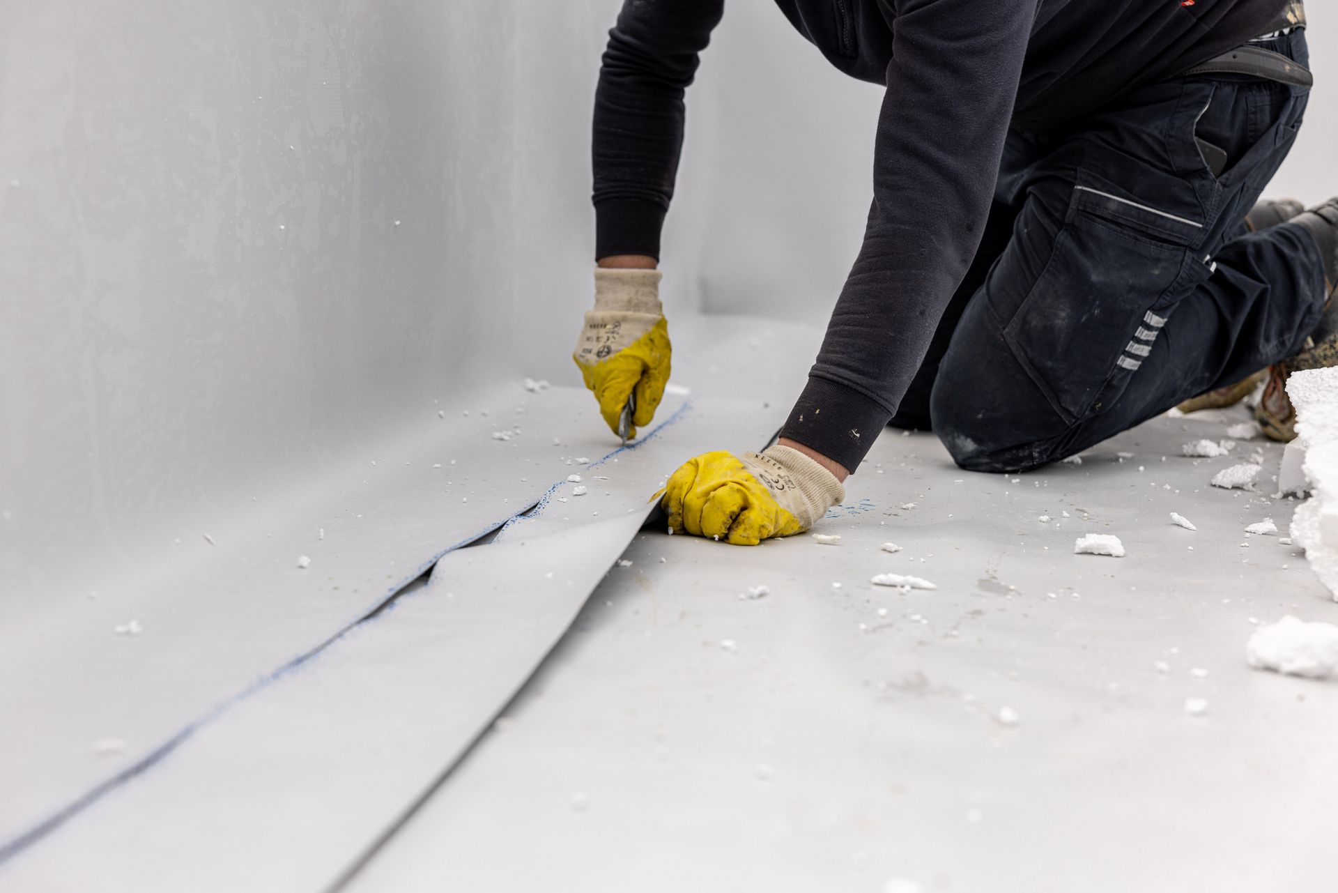 Two construction workers are working on the roof of a building.