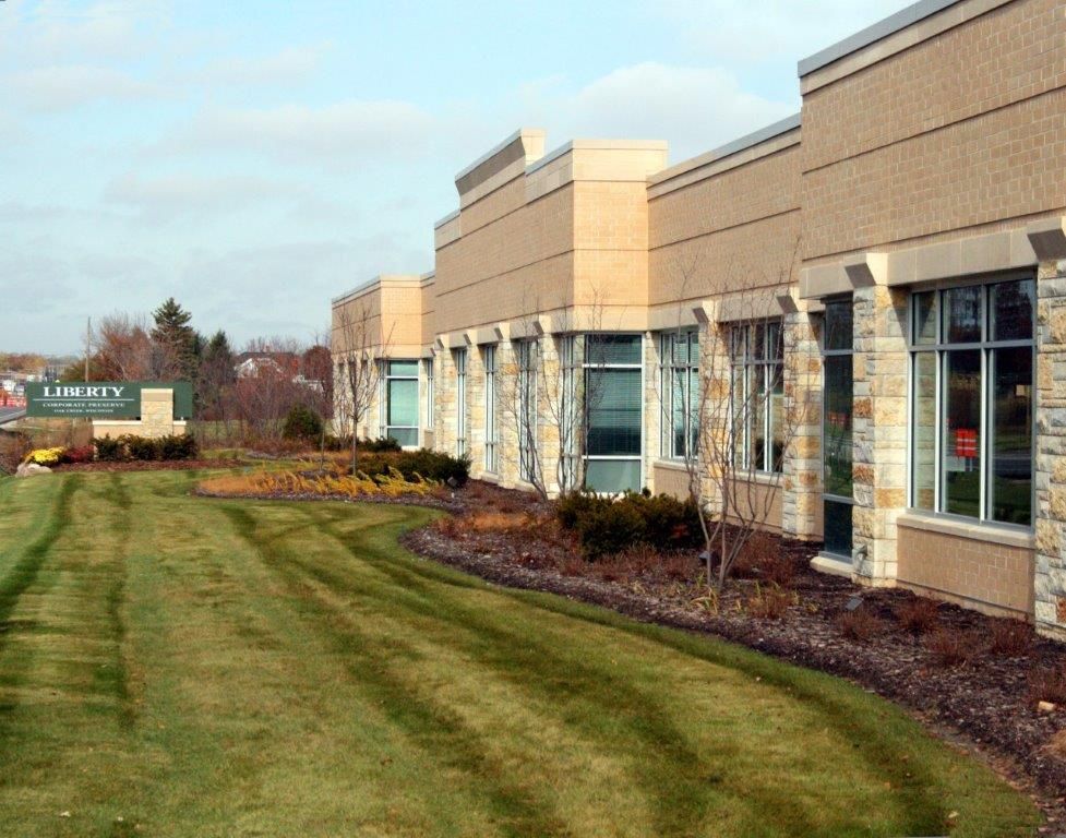 A large building with a lush green lawn in front of it