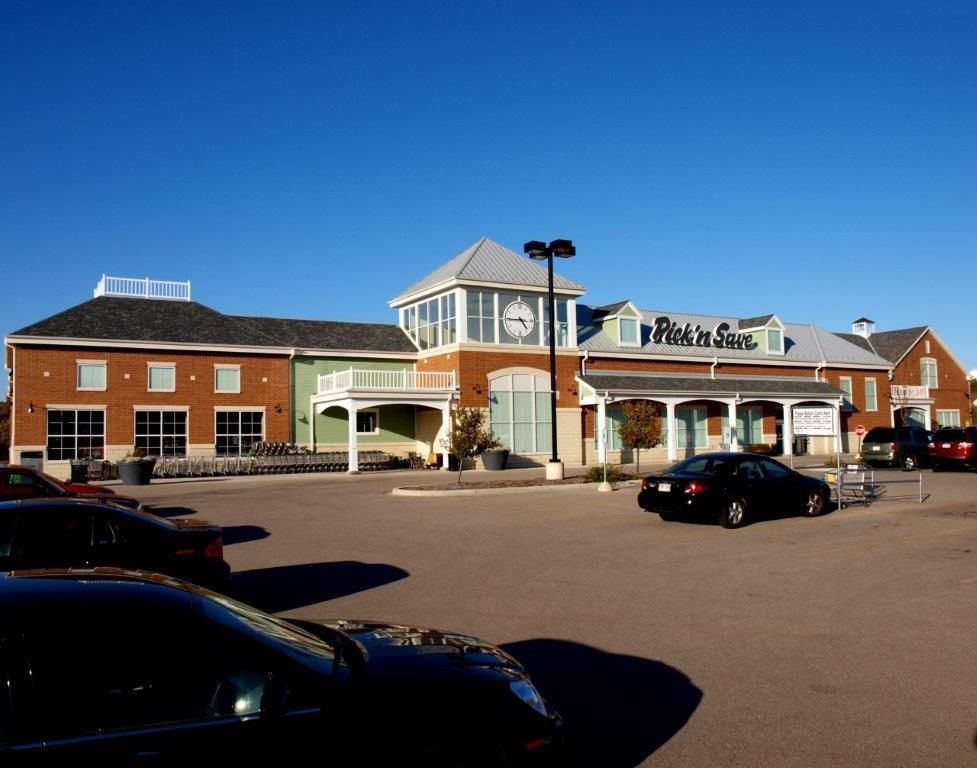 A parking lot with cars parked in front of a building that says robin 's sea