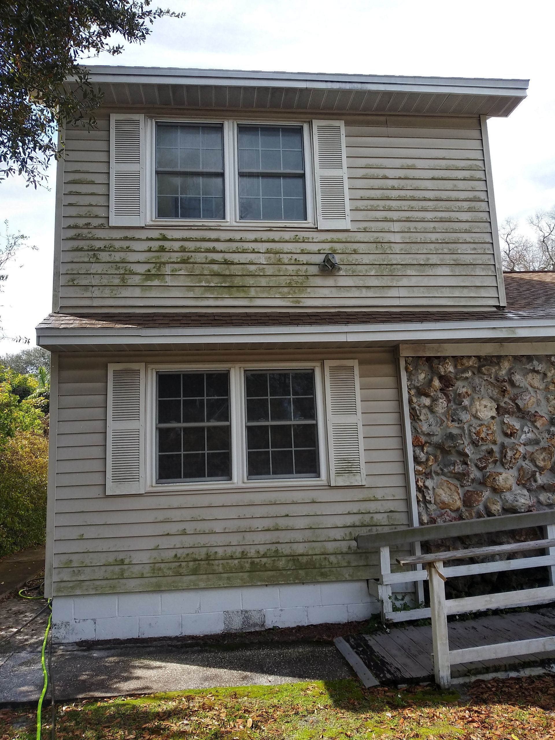 A house with a lot of windows and a stone wall