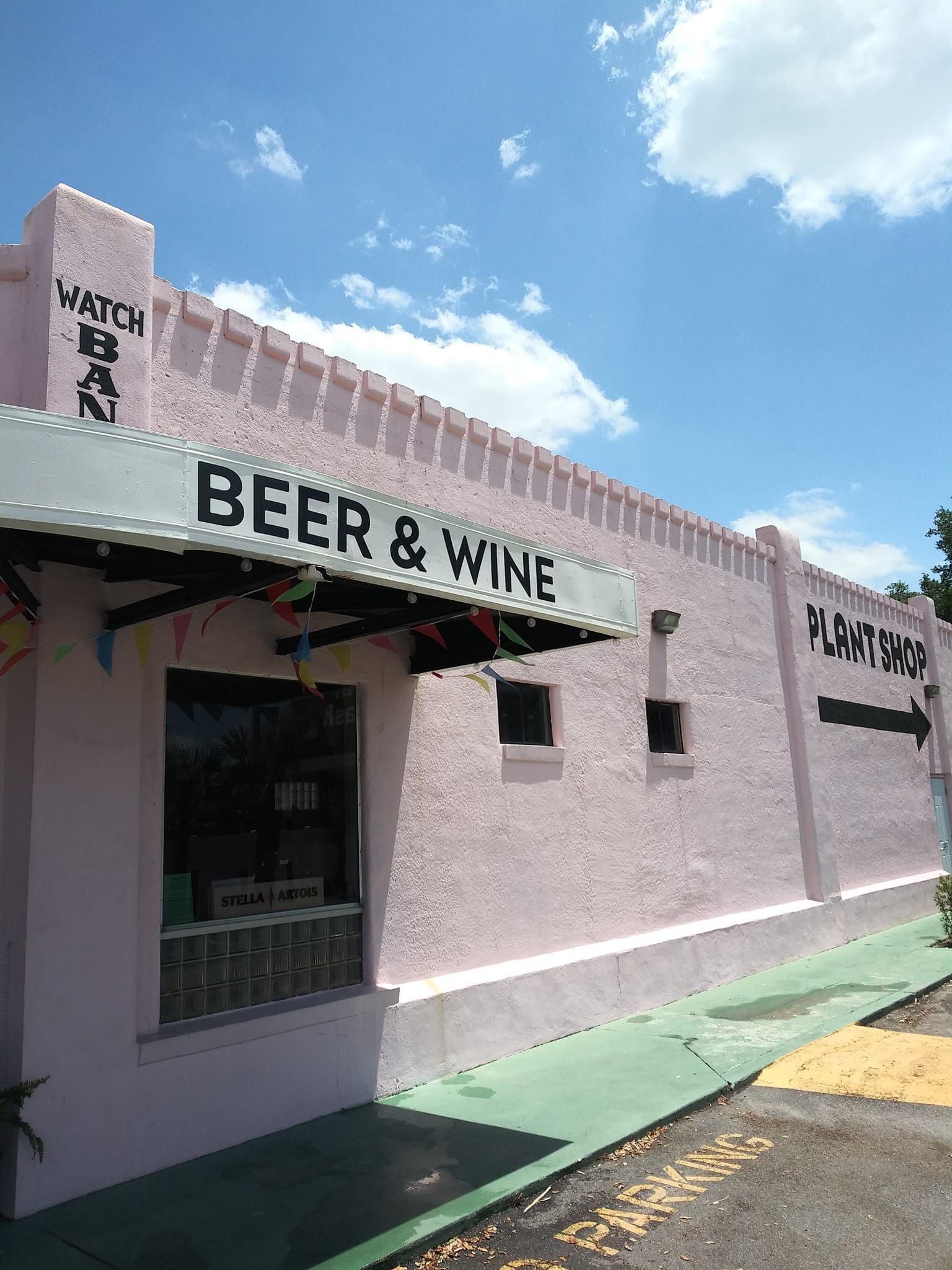 A pink building with a white awning that says beer and wine