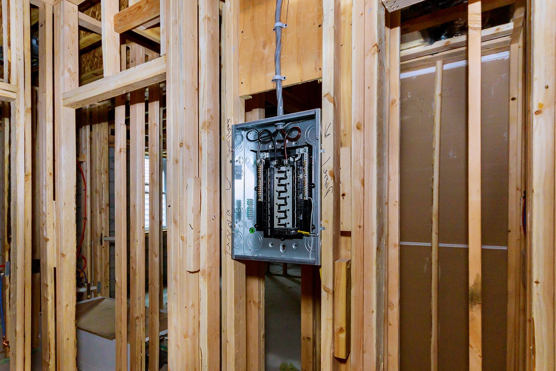 Electrical panel mounted on a wooden frame during home construction.