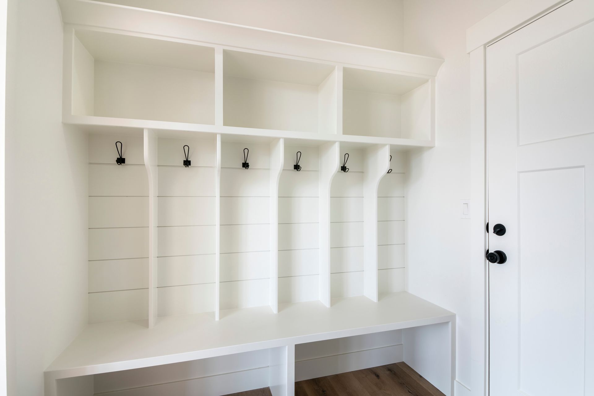Custom white  shelving and cubby space with coat hooks and place for shoes