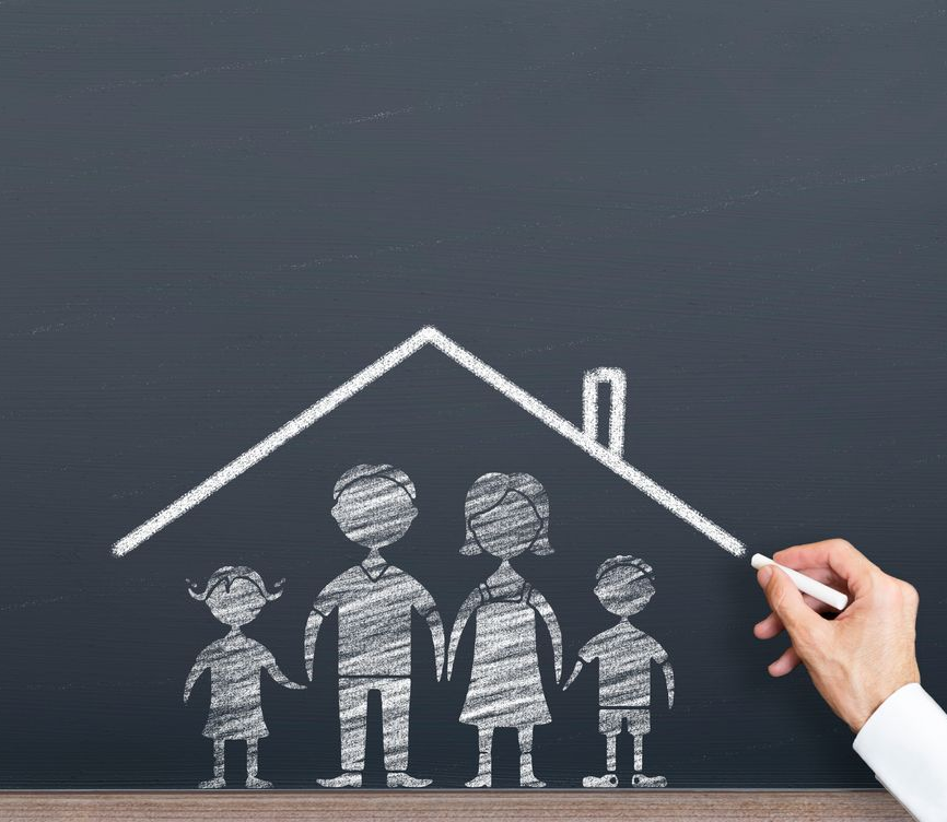 Inspector in hard hat, orange vest, examining the underside of a building's eave.
