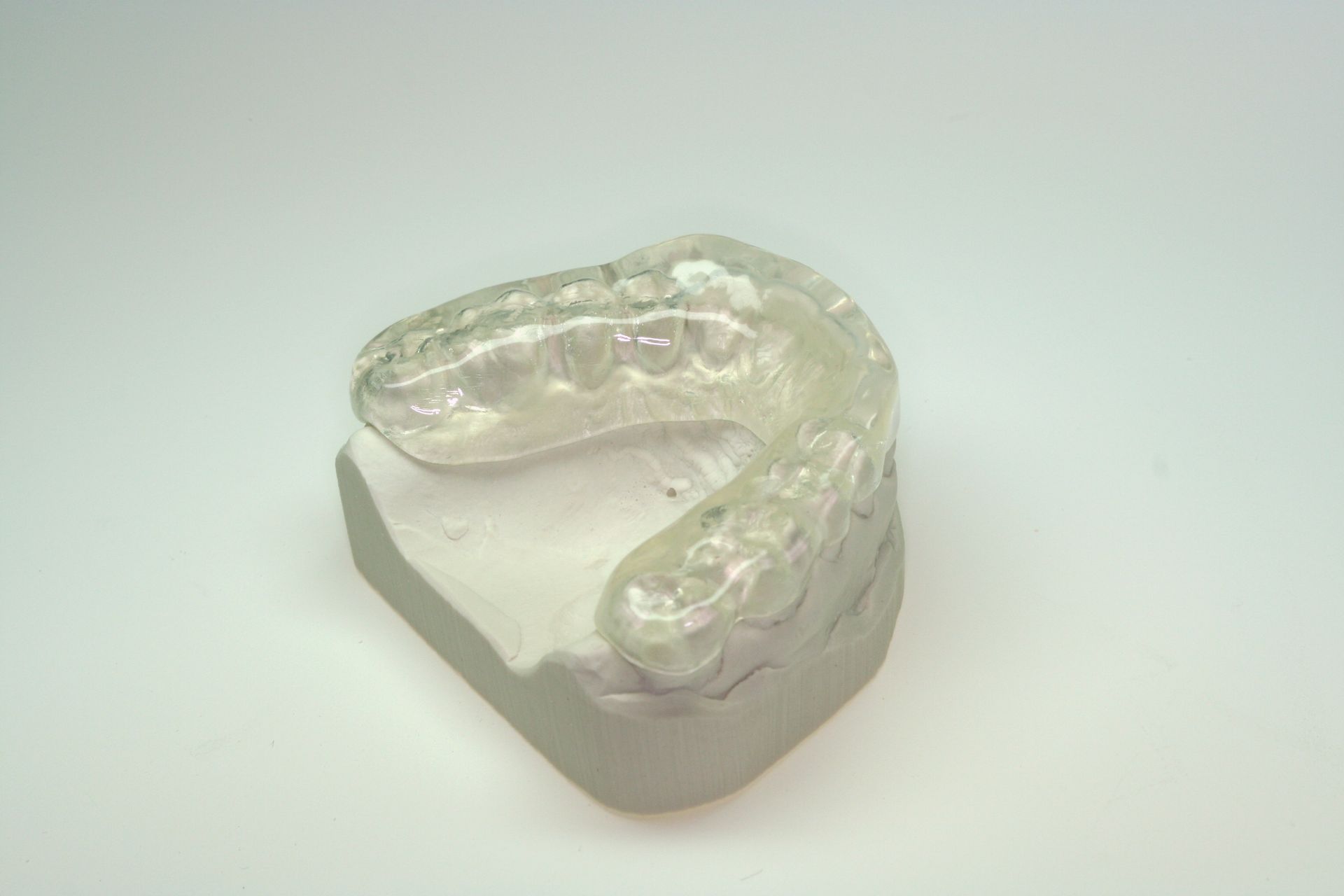 Un protège-dents transparent est posé sur un morceau d'argile.