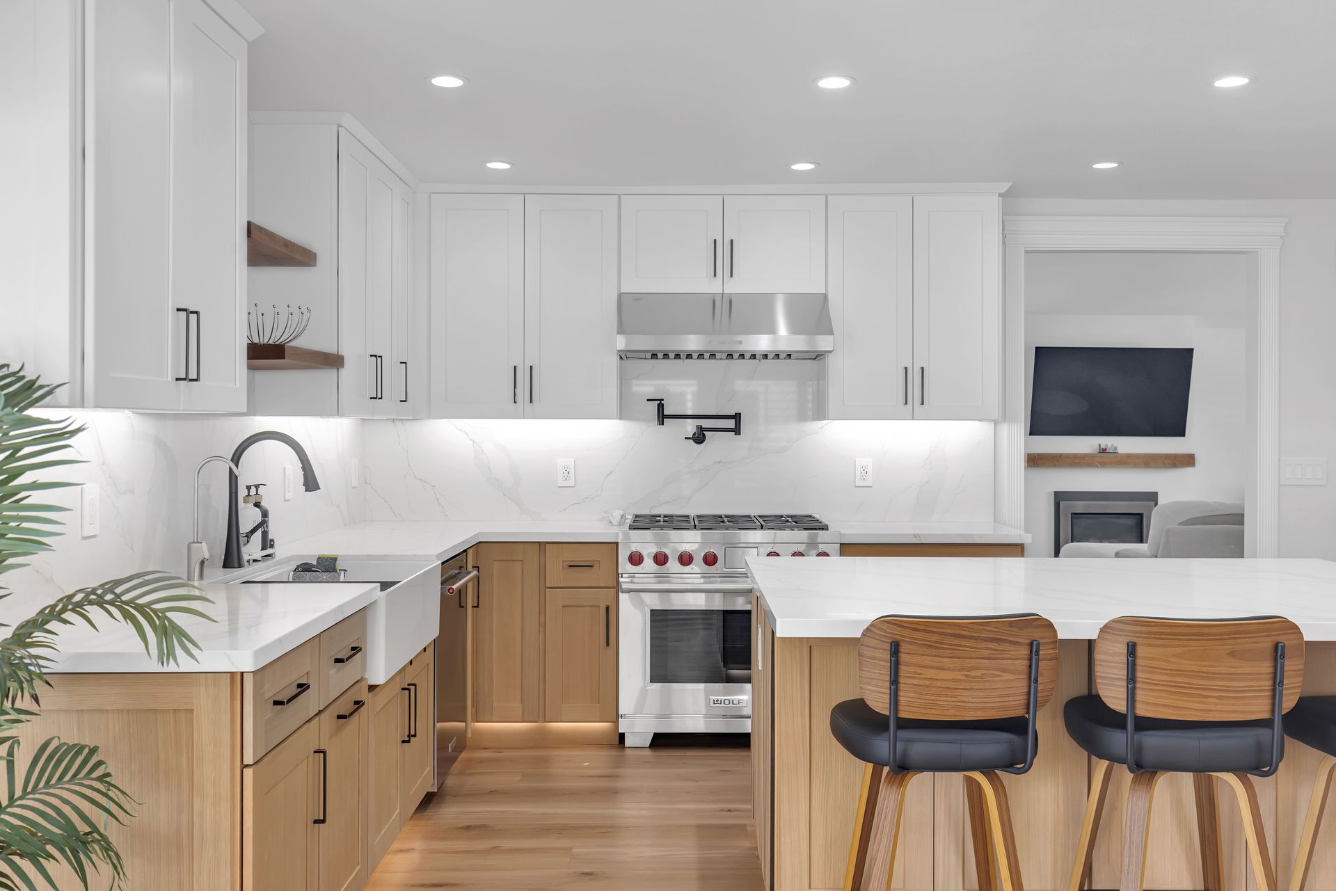 Modern kitchen with white and wood cabinets, white countertops, and stainless steel appliances.