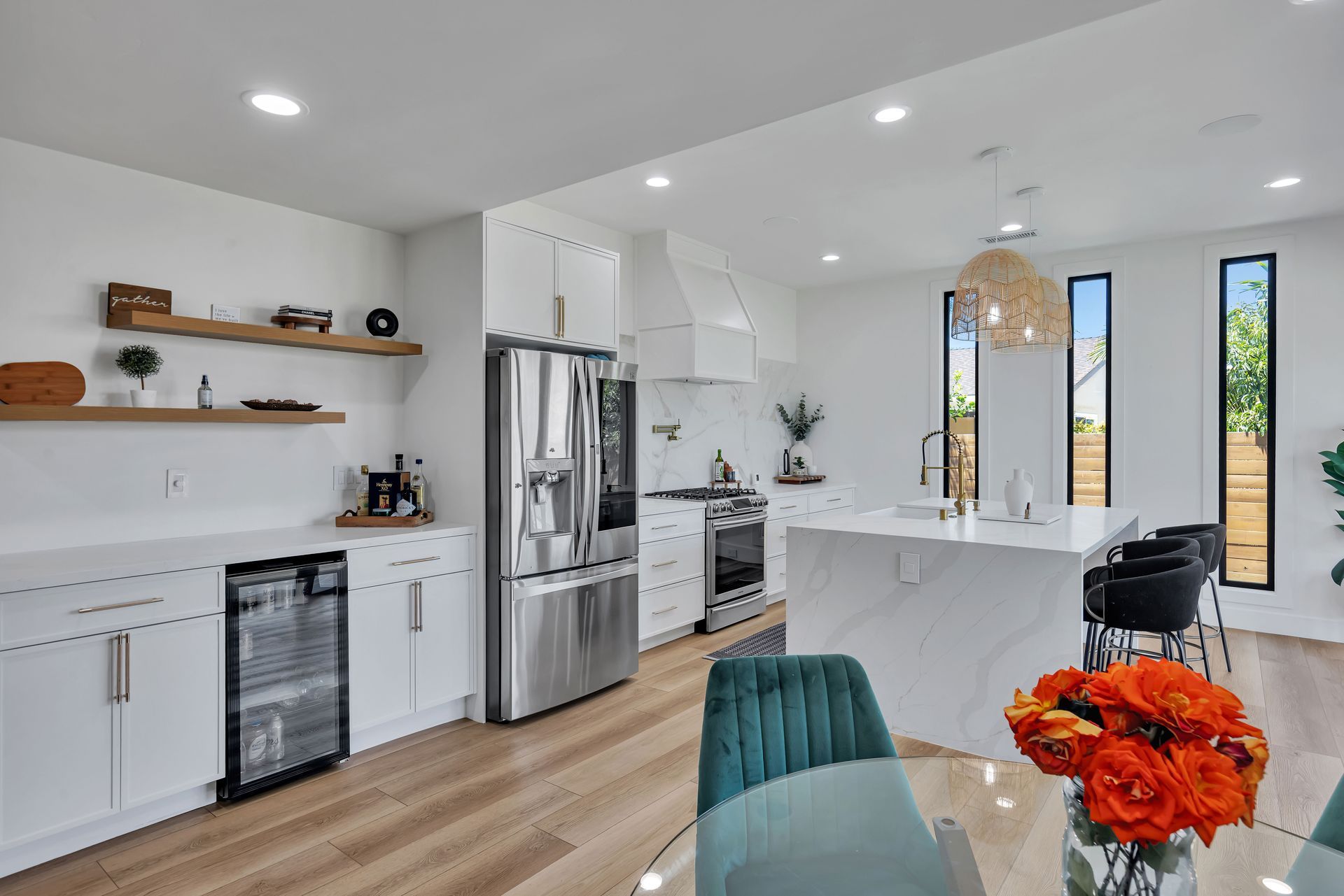 Modern gray-tiled shower with glass door, black fixtures, built-in bench, and small window.