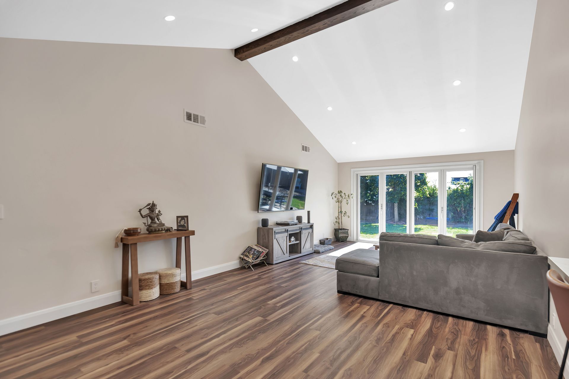 Modern kitchen with light wood cabinetry, white countertops, and two windows.