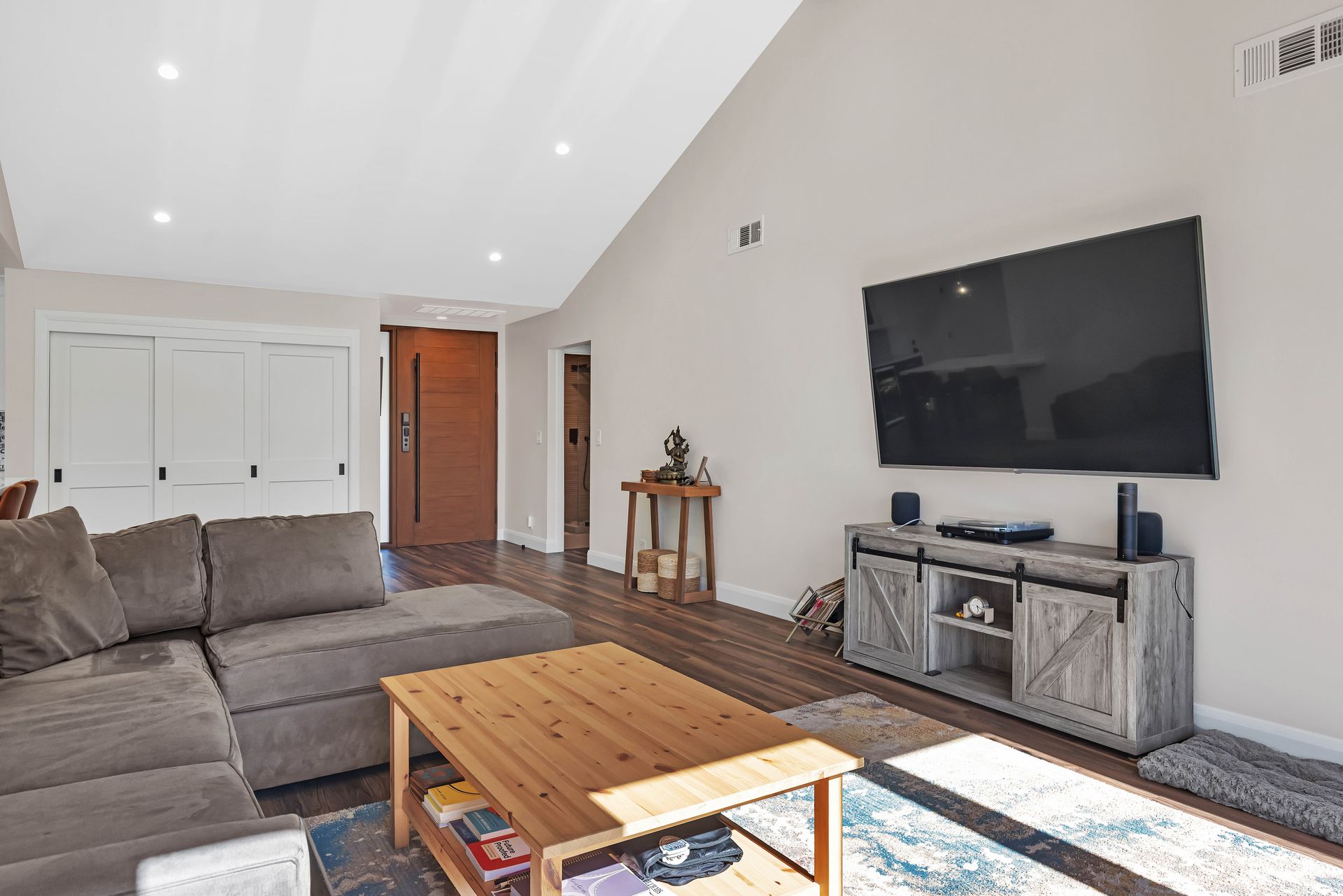 Modern bathroom with glass shower, double vanity, wood cabinets, and white tile.
