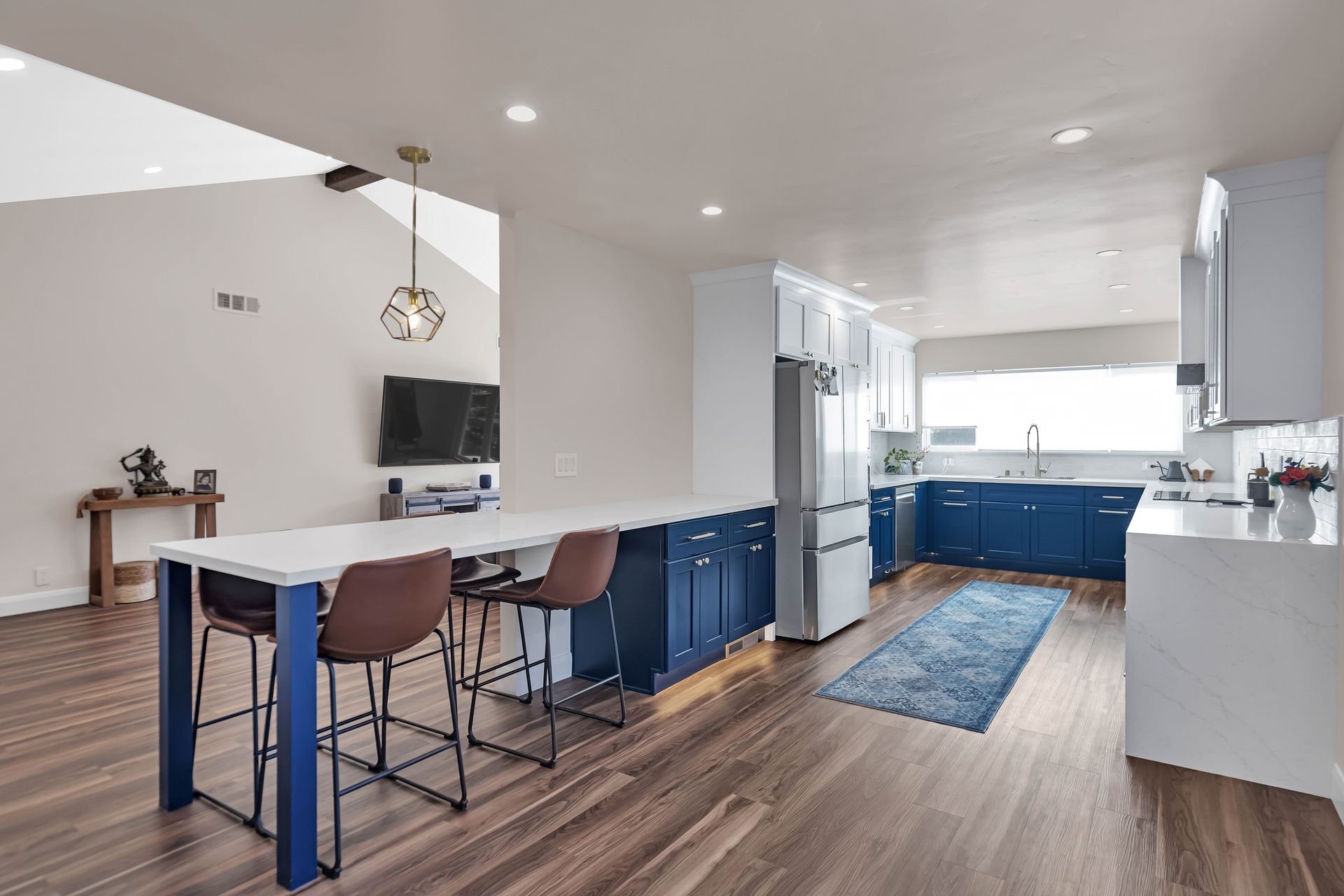 Light beige tiled shower wall with a recessed shelf illuminated by a strip light. Glass shower door is visible.