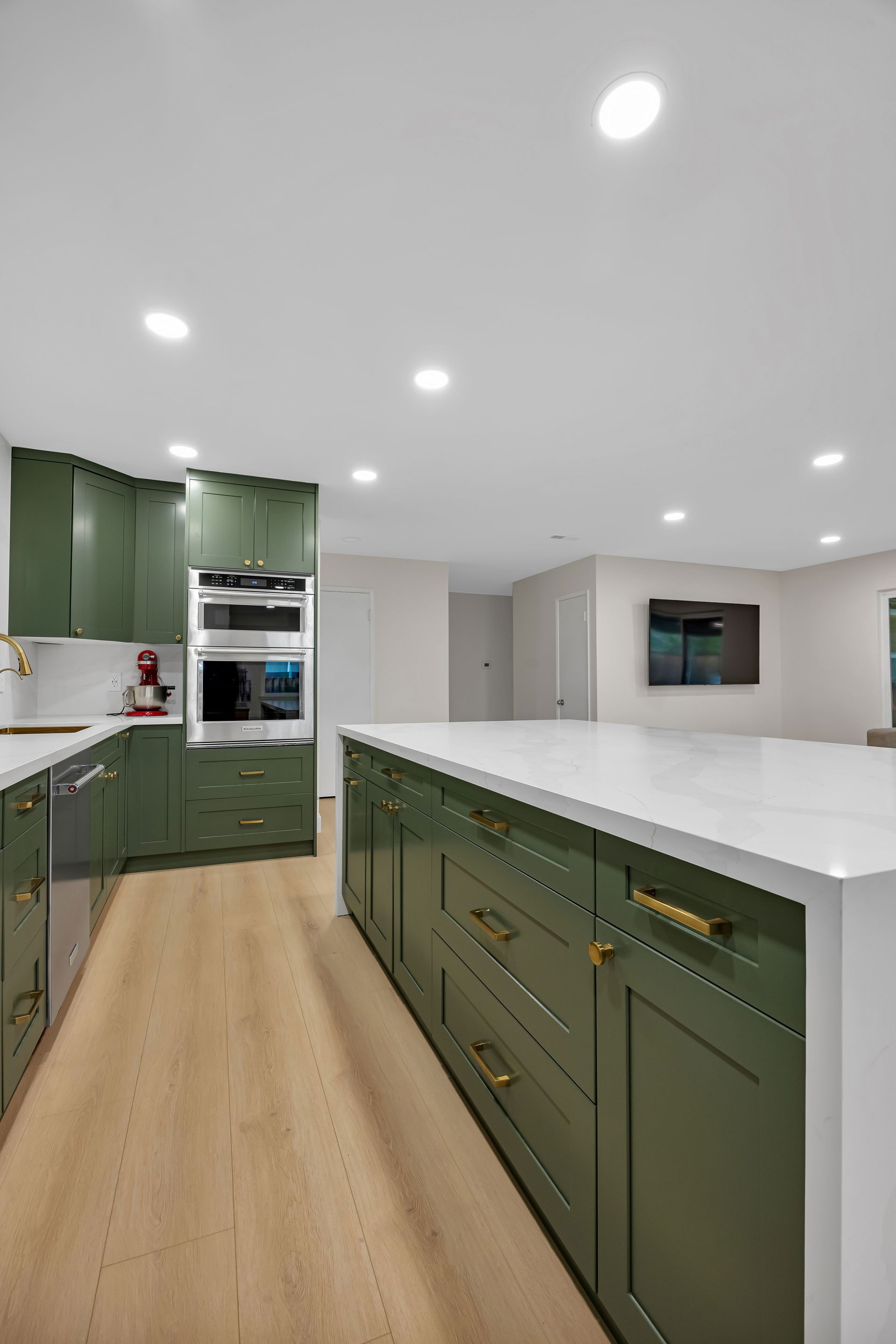 Shower with glass door, recessed shelf with LED lighting, and black fixtures against light gray tiles.