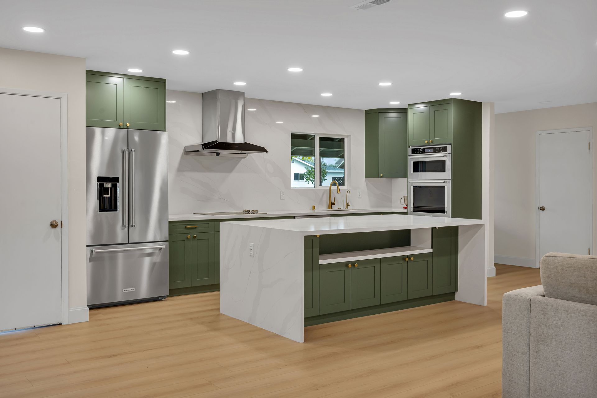 Modern kitchen with marble countertops, wood cabinets, stainless steel appliances, and pendant lighting.