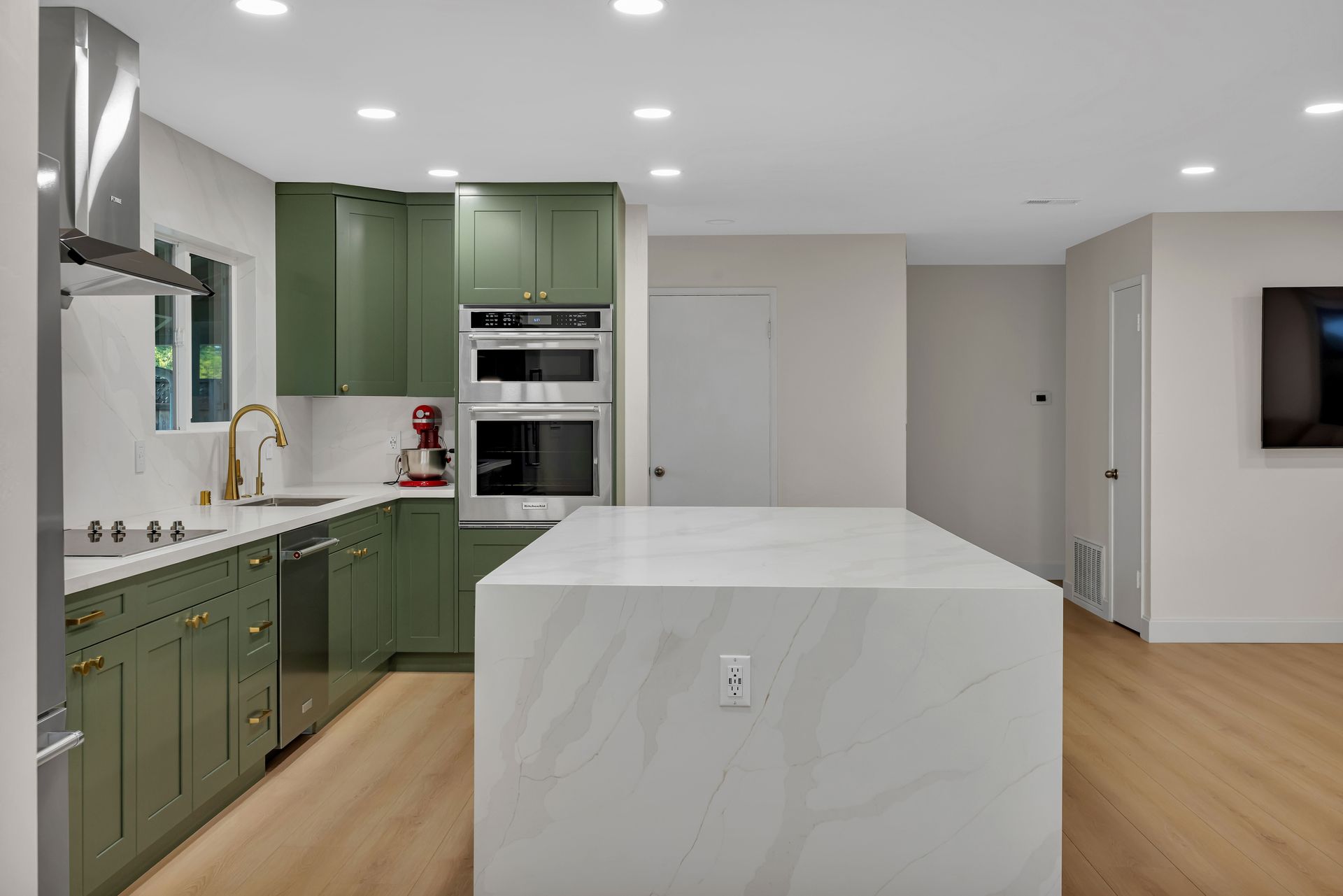 Modern gray-tiled shower with glass door, black fixtures, built-in bench, and small window.