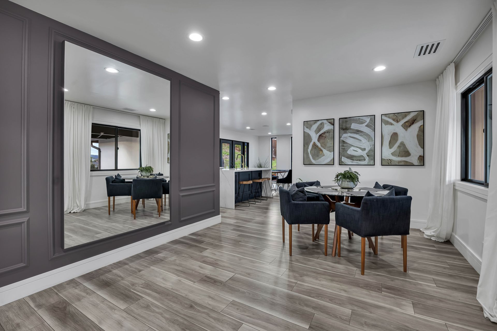 Modern kitchen with marble countertops, wood cabinets, stainless steel appliances, and pendant lighting.