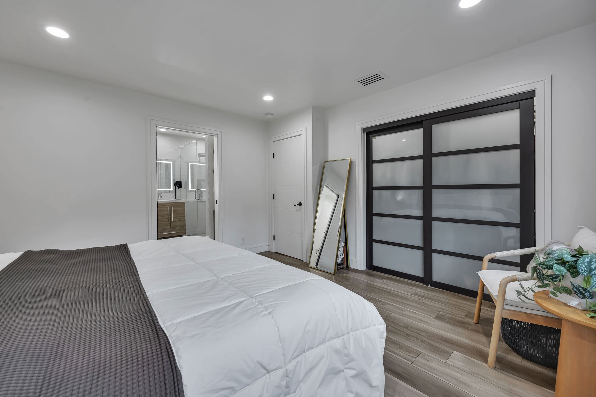 Modern kitchen with green cabinets, white countertops, stainless steel appliances, and a large island.