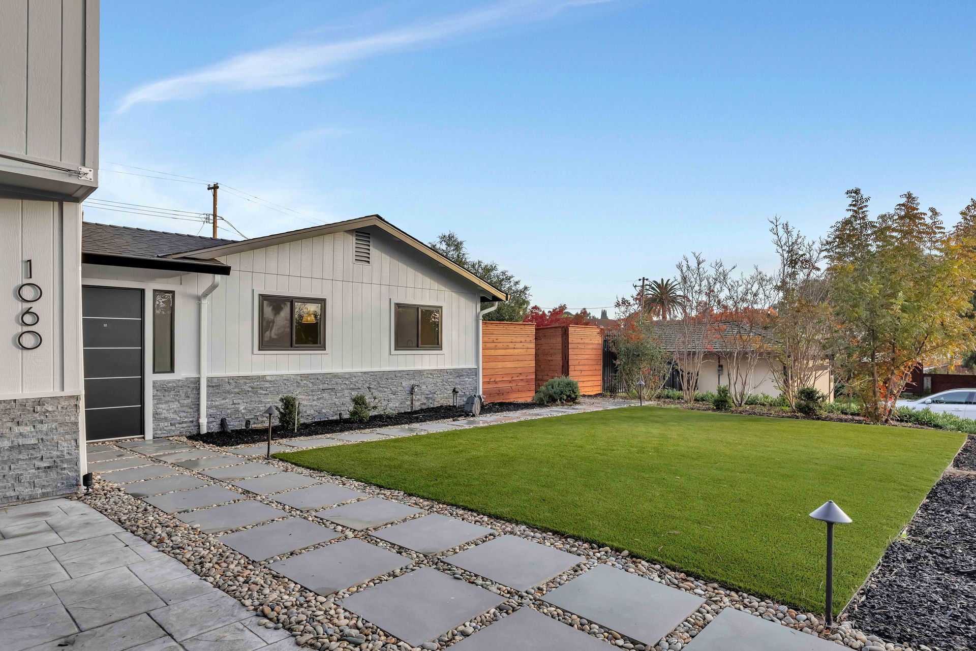 Modern kitchen with marble countertops, wood cabinets, stainless steel appliances, and pendant lighting.