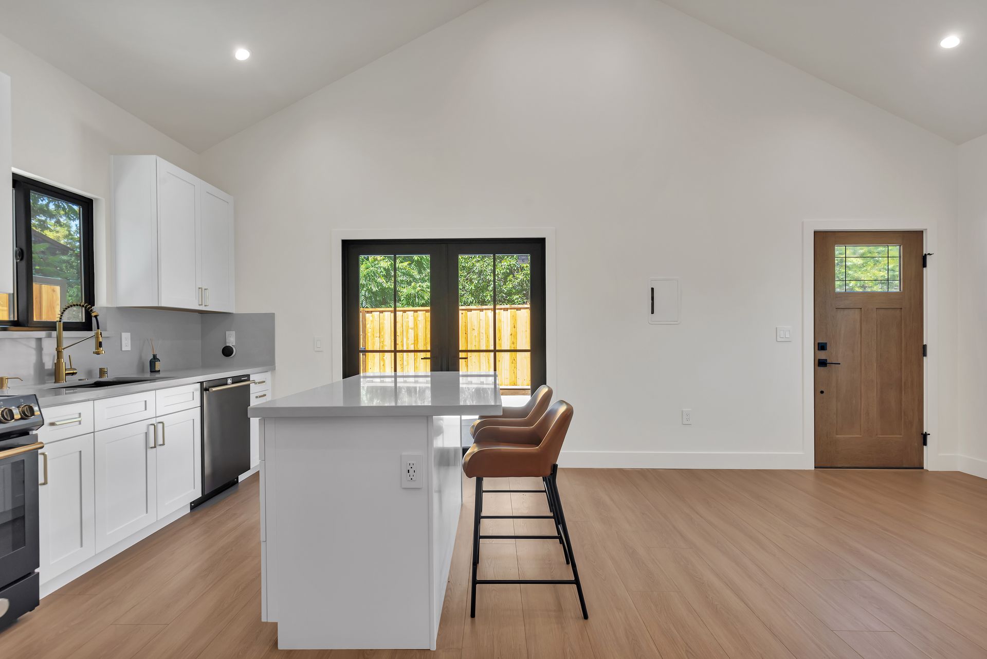 Aerial view of a house with a gray roof and three dormers. Construction equipment is visible in the yard.