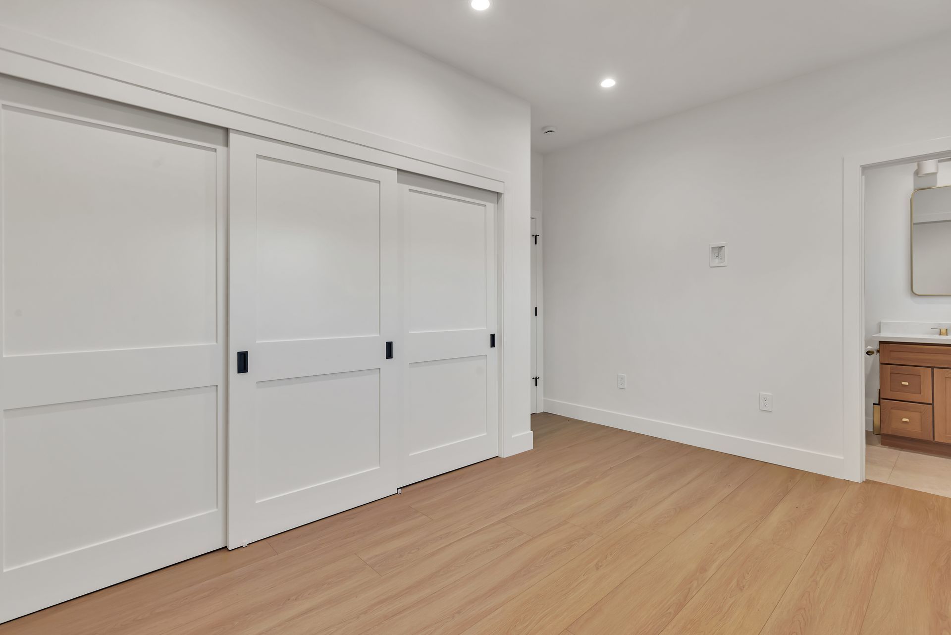 Aerial view of a house with a multi-sloped roof, surrounded by trees and a small construction vehicle.