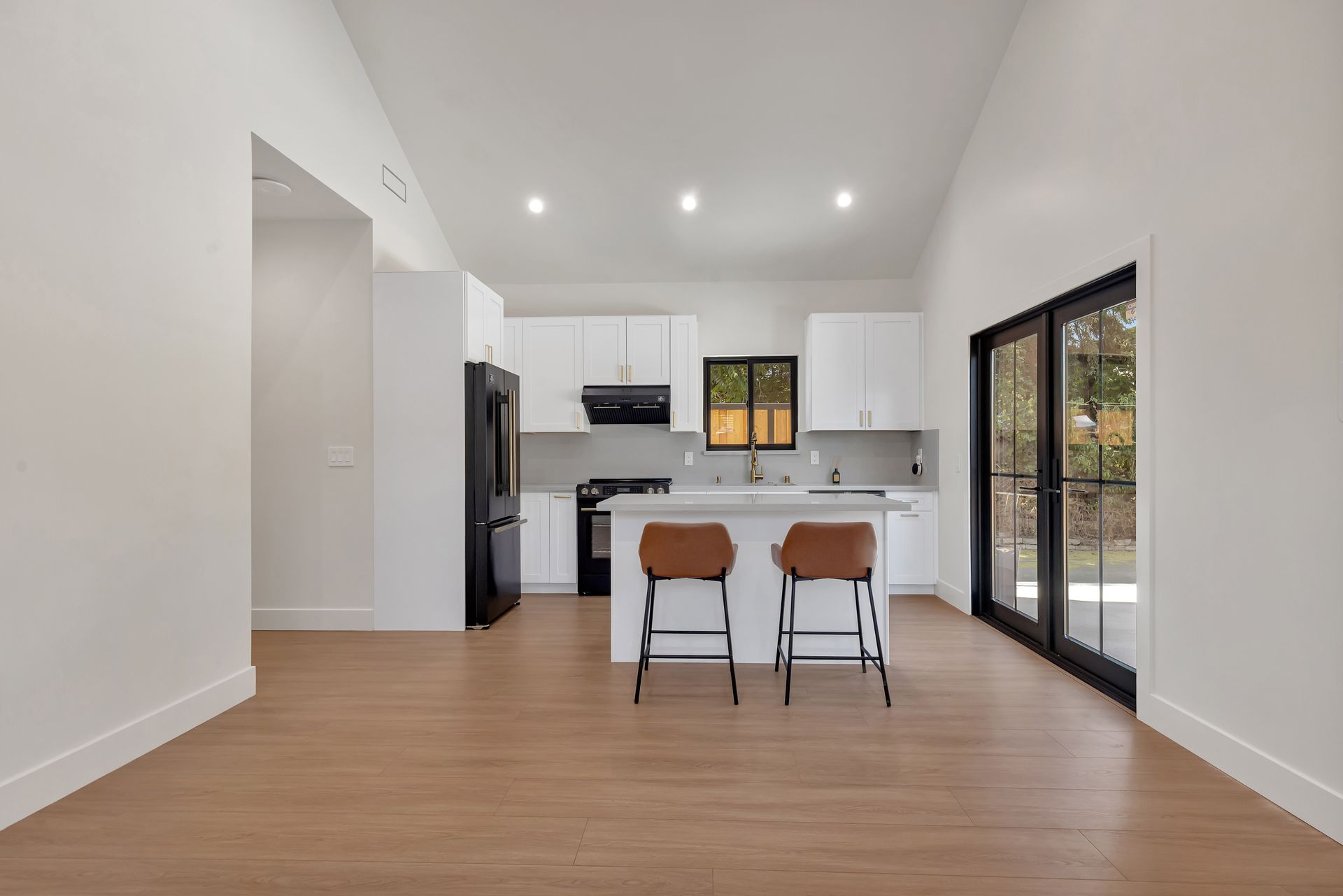 Modern bathroom vanity with black fluted drawers, gold handles, black faucet, and illuminated mirror.