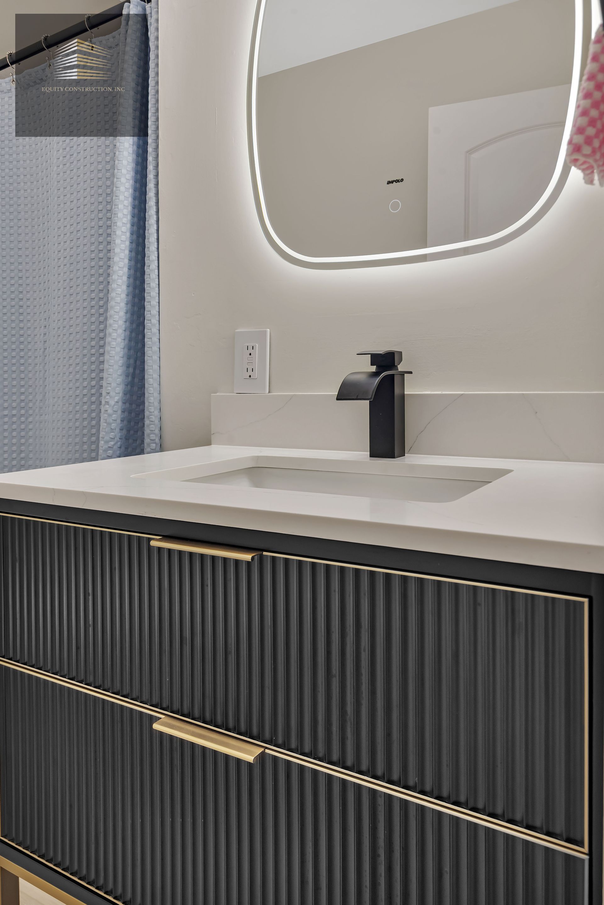 Modern bathroom with wood vanity, white toilet, and glass shower.